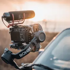 Kamera na stabilizatorze Ronin z mikrofonem RODE, gotowa do filmowania w plenerze.
