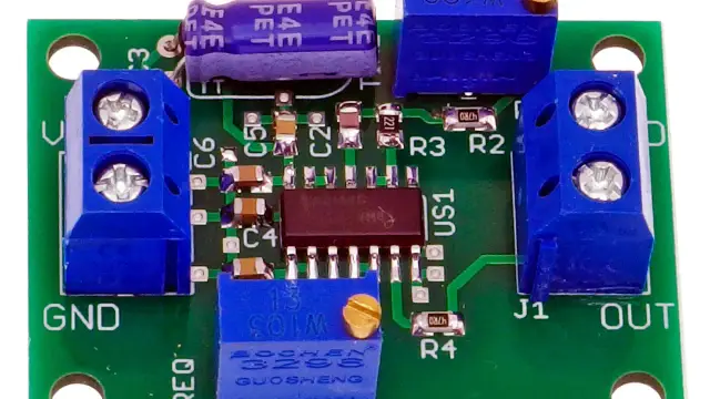 Płytka drukowana z elementami elektronicznymi, w tym kondensatorami, rezystorami i układem scalonym. Widoczne złącza śrubowe GND i OUT, potencjometr oraz oznaczenia elementów. To serce impulsatora.